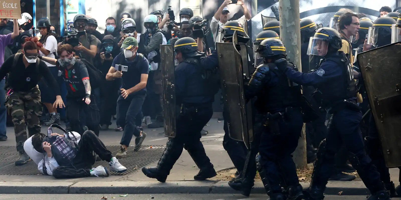 French CRS riot police charge amid clashes with protesters during a demonstration by high school and university students, supported by teachers' union and school parents, in Paris as part of a nationwide day of demonstrations and blockades,